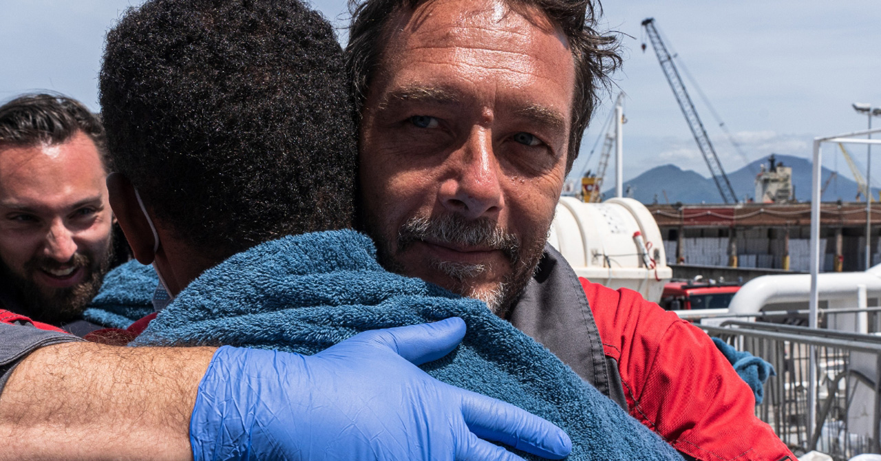 Un cooperante di Emergency avvolge nelle coperte un rifugiato 